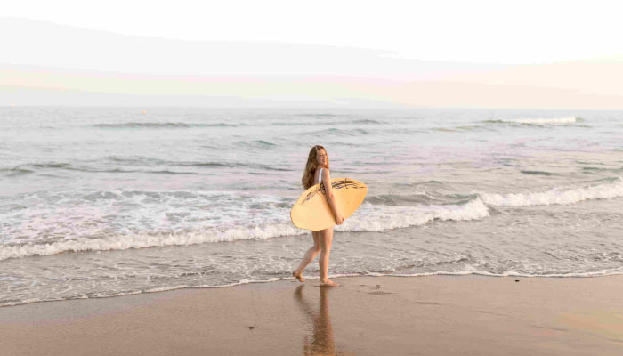 woman with surfboard in hand