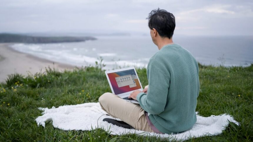 digital nomad working by the sea with laptop